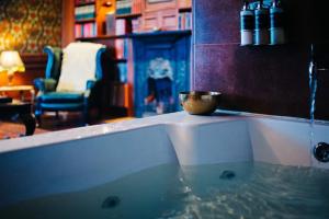 a bath tub with a bowl sitting on top of it at The George Hotel in Inveraray