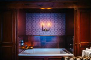 a bathroom with a tub with two candles on the wall at The George Hotel in Inveraray