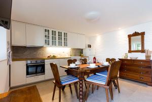 a kitchen with a wooden table and chairs in it at Holiday Home Marija in Dramalj