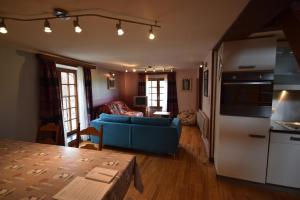 eine Küche und ein Wohnzimmer mit einem blauen Sofa in der Unterkunft Le Chateau De Frankie spas-saunas in Grand-Reng - Erquelinnes