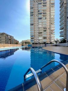 a swimming pool with tall buildings in the background at Condominio Club, Vista para o mar, Churrasqueira in Guarujá