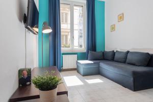 a living room with a blue couch and a table at Secondin Apartment by Wonderful Italy in Turin