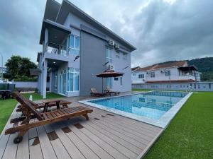 een achtertuin met een zwembad en een huis bij Private Pool Retreat, Langkawi Villa w/ Karaoke by Zervin in Kuah