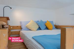 a bedroom with a bed with blue and yellow pillows at Secondin Apartment by Wonderful Italy in Turin