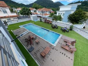 een uitzicht over een zwembad in een tuin bij Private Pool Retreat, Langkawi Villa w/ Karaoke by Zervin in Kuah