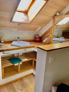een badkamer op zolder met 2 wastafels en een dakraam bij Esparoutis Chambres d'hôtes du Charme in Saint-Cybranet