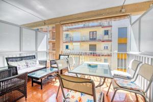 uma varanda com uma mesa e cadeiras e um edifício em Relax Les Palmeres em Valência