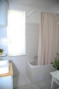 La salle de bains est pourvue d'une baignoire et d'un rideau de douche. dans l'établissement Lux Apartment Duje, à Split