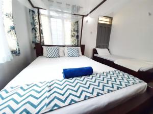 Schlafzimmer mit einem großen Bett mit blauer und weißer Bettwäsche in der Unterkunft Cycad Palm Diani in Diani Beach