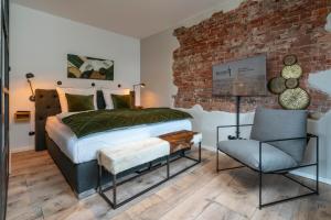 een slaapkamer met een bed en een bakstenen muur bij Apart Hotel Wasserturm in Bad Segeberg