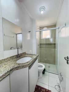 een badkamer met een wastafel en een toilet bij Condominio Club, Vista para o mar, Churrasqueira in Guarujá