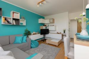uma sala de estar com paredes azuis e um sofá cinzento em Metro Wilanowska Apartment with Parking by Renters em Varsóvia