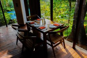 a wooden table with chairs on a wooden deck at De Foret in Havelock Island