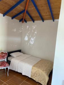 - une chambre avec un lit et une chaise rouge dans l'établissement Posada Campestre Agua Bonita, à Pueblorrico