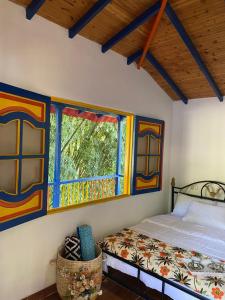 - une chambre avec un lit et une fenêtre dans l'établissement Posada Campestre Agua Bonita, à Pueblorrico
