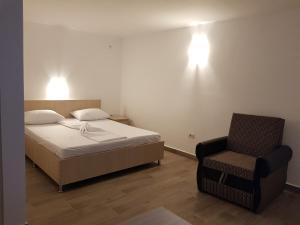 1 dormitorio con 1 cama y 1 silla en EVANA HOUSE, en Costinesti