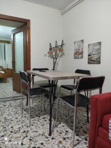 a dining room with a wooden table and chairs at Vicky's House in Kymi