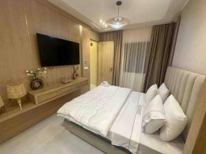 een slaapkamer met een groot bed en een flatscreen-tv bij Appartement de Luxe à Tanger in Tanger