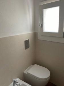 a bathroom with a white toilet and a window at sweet home in Carloforte