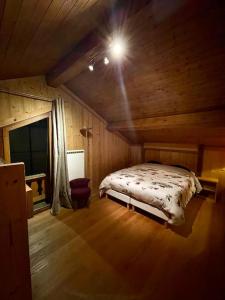 1 dormitorio con 1 cama en una cabaña de madera en Le Roc - Courchevel Village, en Courchevel