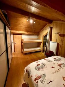 1 dormitorio con 1 cama en una habitación de madera en Le Roc - Courchevel Village, en Courchevel