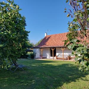 una casa bianca con una panchina in un cortile di Florie Cottage a Cserszegtomaj