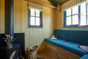 a blue bench in a room with two windows at Rufflets St Andrews in St. Andrews