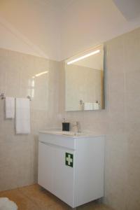 a bathroom with a white sink and a mirror at Lugar dos Louros 1 in Estreito da Calheta +16 photos