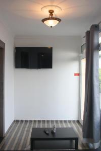 een woonkamer met een tafel en een tv aan de muur bij Lugar dos Louros 1 in Estreito da Calheta