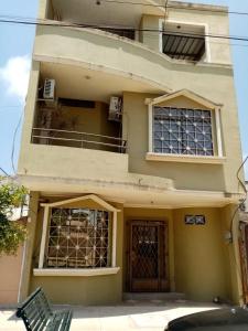 un edificio amarillo con puerta y balcón en Espacio familiar Poma en Machala