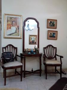 a room with two chairs and a table and a mirror at Espacio familiar Poma in Machala