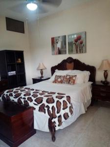 a bedroom with a large bed with a brown and white blanket at Espacio familiar Poma in Machala