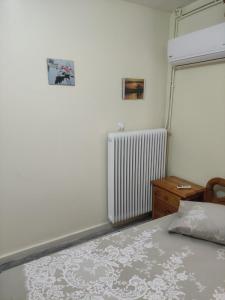 a bedroom with a bed and a radiator at Vicky's House in Kymi