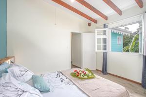 a bedroom with a bed with a bowl of flowers on it at Villa Patio Azur in Les Trois-Îlets