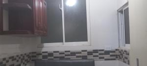 eine Küche mit einem Waschbecken und einem Fenster darin in der Unterkunft Premium Single Room in Corales del Sur, Santo Domingo Este - Ole Las Americas in La Viva