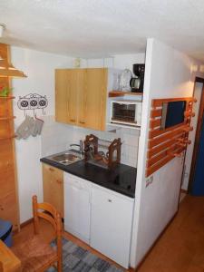 a small kitchen with a sink and a refrigerator at Paradiski proches pistes et commerces vallandry in Landry