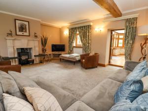 uma sala de estar com um sofá e uma lareira em Manor Farm em Cheltenham