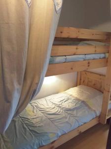 a wooden bunk bed with a curtain over it at Paradiski proches pistes et commerces vallandry in Landry