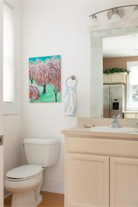 a bathroom with a toilet and a painting on the wall at The Townhouse in the Heart of the City in Traverse City +24 photos