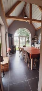 a dining room with a table and a fireplace at B & B Victors Hof, met zwemvijver en leuke diertjes in Lievegem