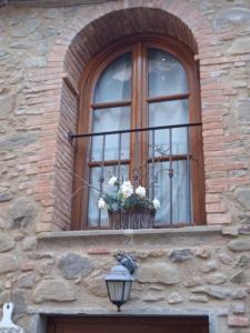 ein Fenster mit einem Blumenkorb auf dem Balkon in der Unterkunft La Tana Nel Castelvecchio in Giampierone