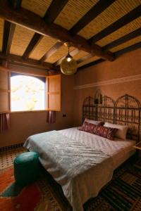 een slaapkamer met een bed en een groot raam bij DAR NOUR in Tafraoute