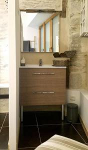 La salle de bains est pourvue d'un lavabo et d'un miroir. dans l'établissement LE P'TIT APPART, à Landerneau