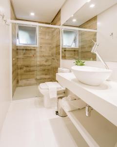uma casa de banho com um lavatório, um WC e um chuveiro em Hospedaria das Brisas na Praia do Rosa