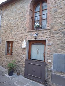 ein Steingebäude mit einer Tür und zwei Fenstern in der Unterkunft La Tana Nel Castelvecchio in Giampierone