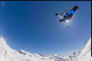 a man flying through the air on a ski lift at Très Joli T2 aux pieds des pistes avec Balcon in Orcières