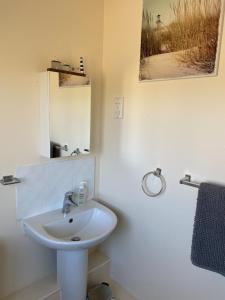 a white bathroom with a sink and a mirror at River Penthouse Little Paxton - 75 Skipper Way in Saint Neots