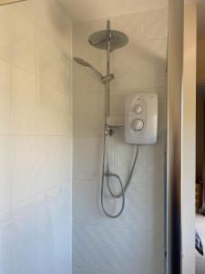 a shower with a shower head in a bathroom at River Penthouse Little Paxton - 75 Skipper Way in Saint Neots