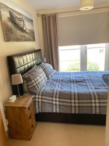 a bedroom with a bed and a window at River Penthouse Little Paxton - 75 Skipper Way in Saint Neots