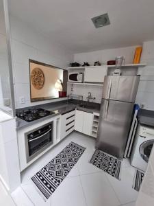 cocina con armarios blancos y nevera de acero inoxidable en LINDISSIMO IPANEMA, 2 SUÍTES en Río de Janeiro